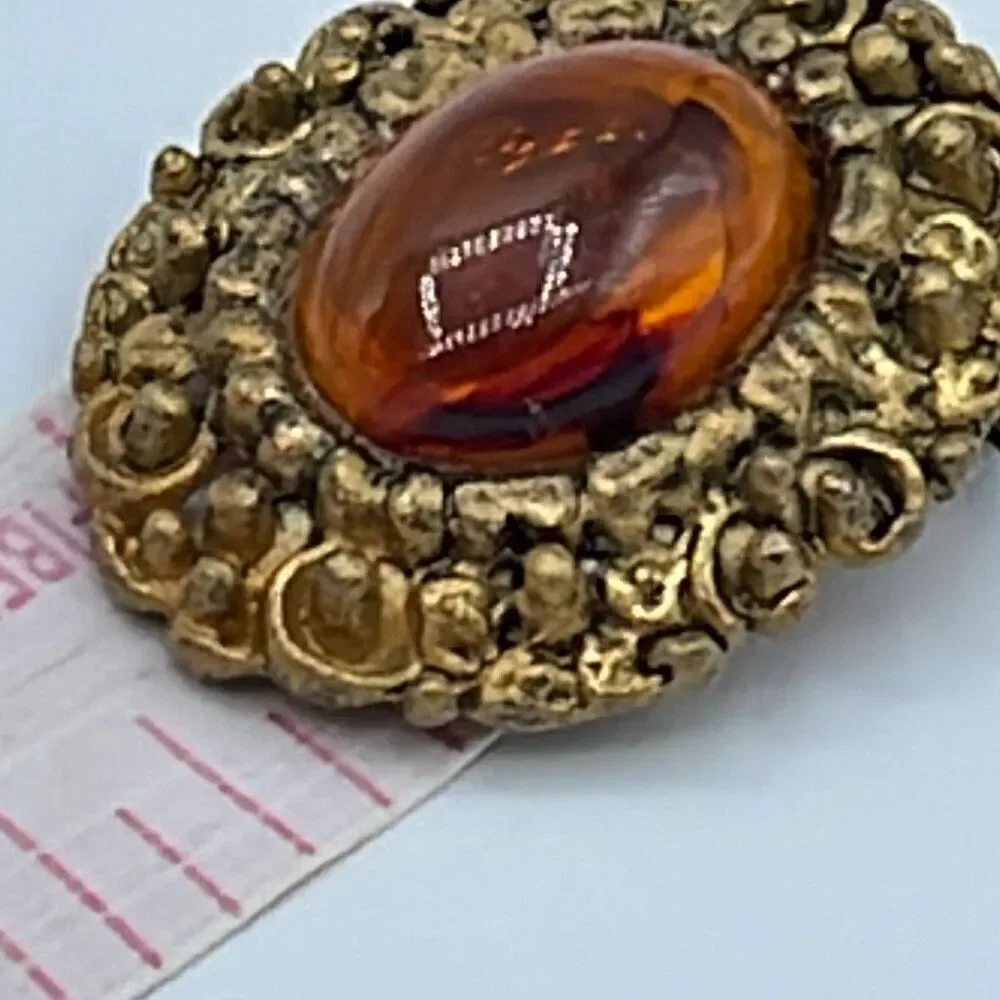 Vintage ornate amber colored brooch.